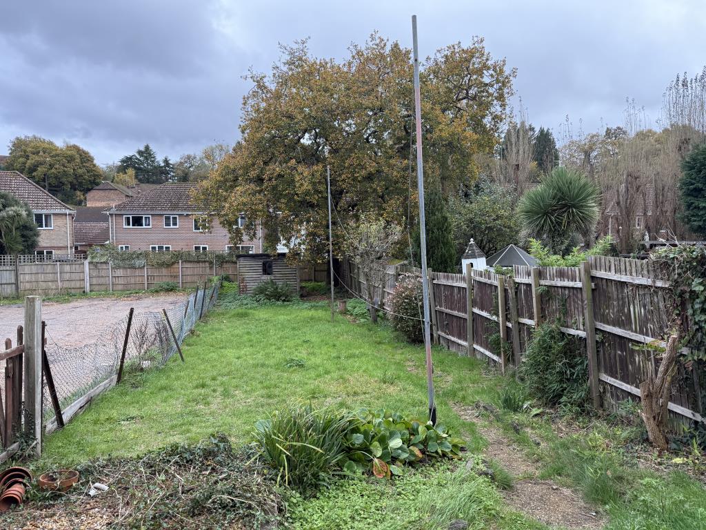 Lot: 105 - THREE-BEDROOM HOUSE IN NEED OF IMPROVEMENT - Garden with wooden shed and grass lawn